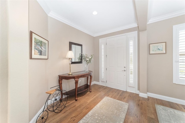 entrance foyer featuring plenty of natural light, ornamental molding, and light wood-type flooring