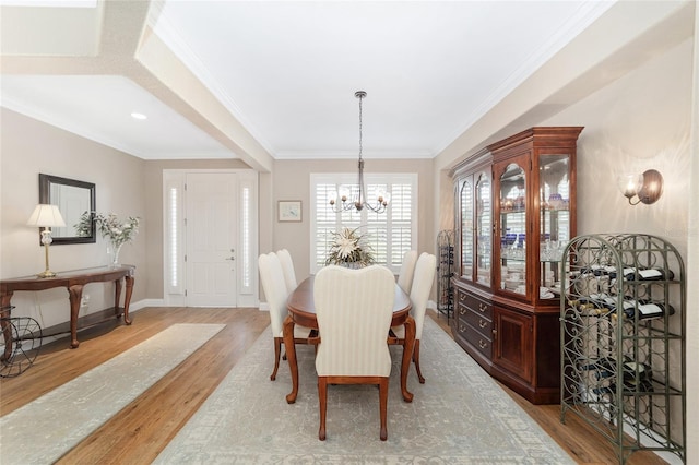 dining room featuring a notable chandelier, crown molding, and light hardwood / wood-style flooring