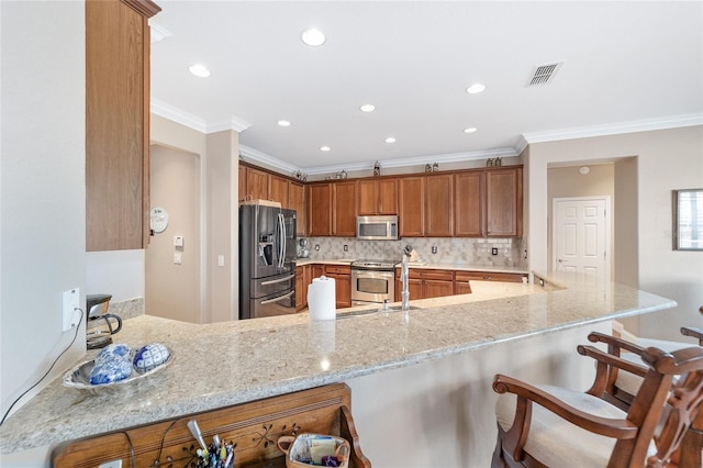 kitchen with a breakfast bar, kitchen peninsula, appliances with stainless steel finishes, and light stone counters