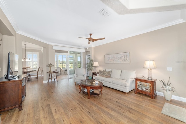 living room with ceiling fan, crown molding, light hardwood / wood-style flooring, and built in shelves