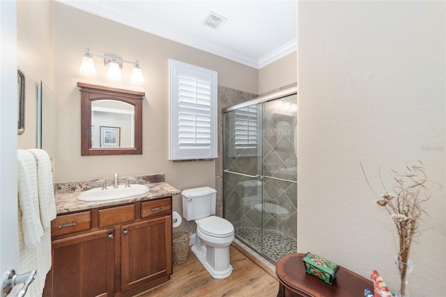 bathroom featuring wood-type flooring, vanity, toilet, walk in shower, and crown molding