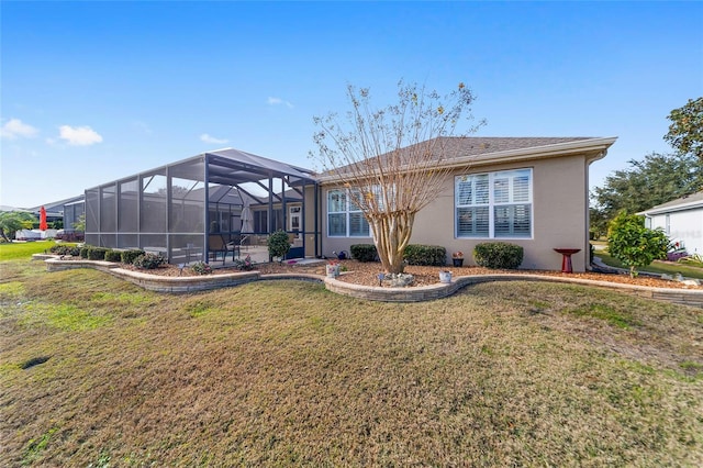 rear view of house with a lanai and a yard