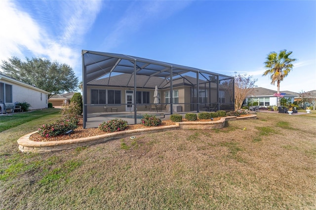 rear view of property featuring glass enclosure, a pool, a yard, and a patio