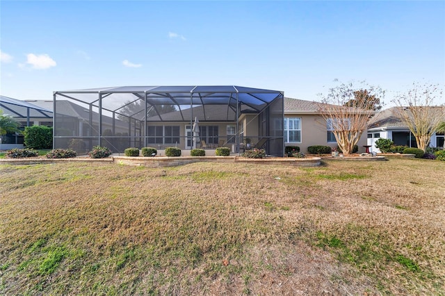 rear view of property with a lanai and a lawn