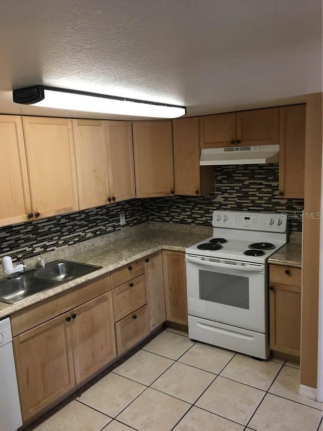 kitchen with a textured ceiling, light tile patterned floors, sink, and white appliances