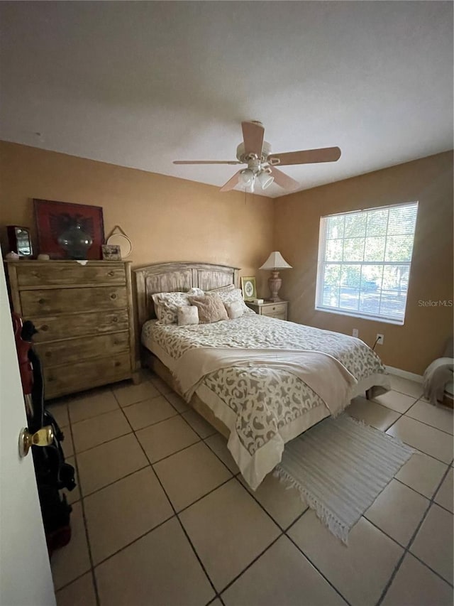 bedroom with ceiling fan and light tile patterned floors