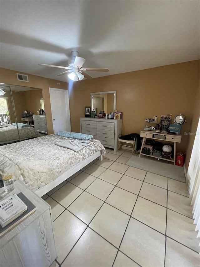 tiled bedroom featuring ceiling fan