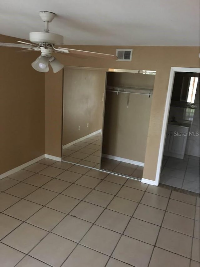 unfurnished bedroom featuring ceiling fan, a closet, and tile patterned flooring