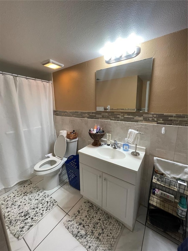 bathroom featuring tile walls, tile patterned floors, vanity, and a textured ceiling