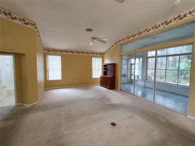 unfurnished living room featuring lofted ceiling, light colored carpet, and ceiling fan