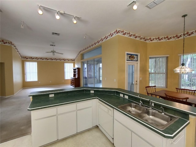 kitchen featuring sink, dishwasher, ceiling fan, white cabinetry, and hanging light fixtures