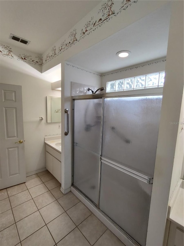 bathroom featuring vanity, tile patterned floors, and walk in shower