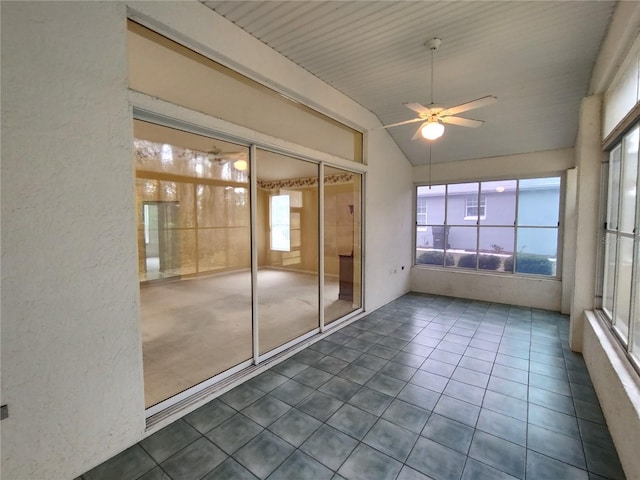 unfurnished sunroom with ceiling fan and vaulted ceiling