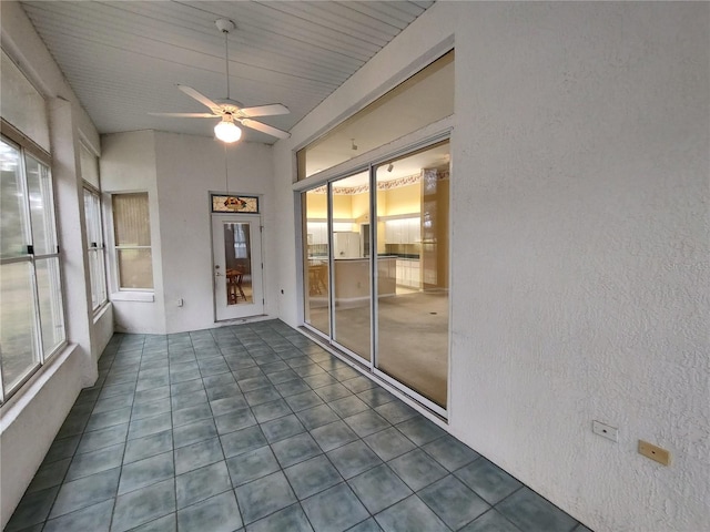 unfurnished sunroom featuring ceiling fan