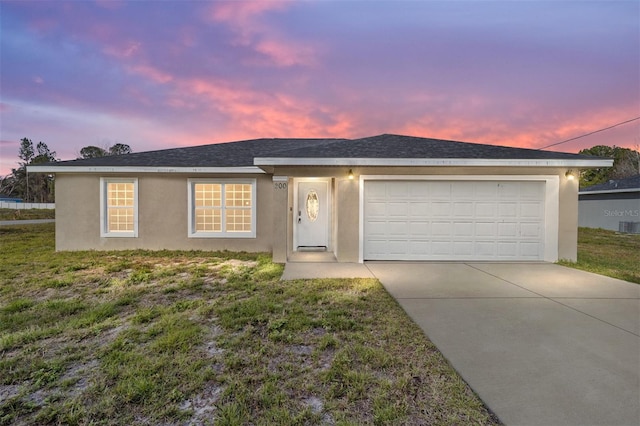 ranch-style house featuring a garage and a yard