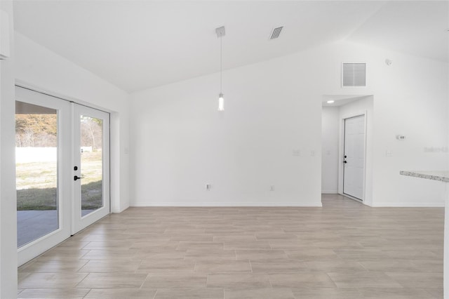 spare room featuring french doors and lofted ceiling