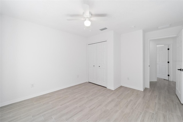 empty room with ceiling fan and light hardwood / wood-style floors