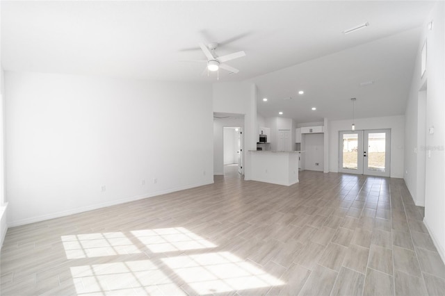 unfurnished living room featuring light hardwood / wood-style flooring, vaulted ceiling, french doors, and ceiling fan