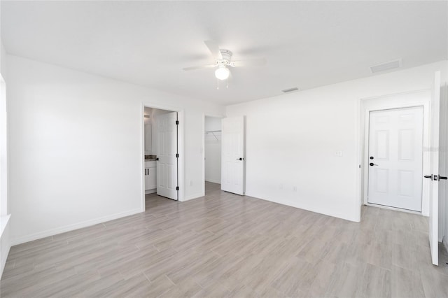 empty room with ceiling fan and light hardwood / wood-style floors