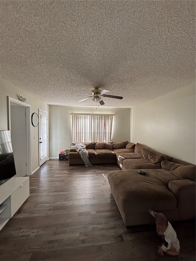 living room with a textured ceiling, ceiling fan, and dark hardwood / wood-style floors