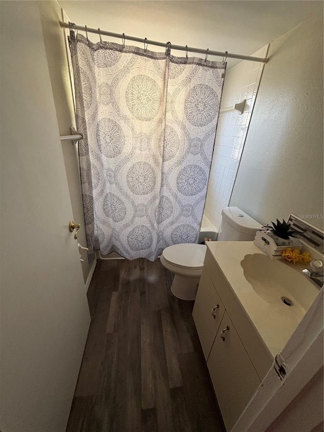 full bathroom featuring toilet, shower / bath combo, hardwood / wood-style flooring, and vanity