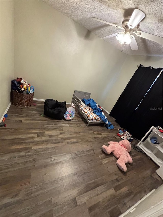 unfurnished bedroom with ceiling fan, a textured ceiling, and hardwood / wood-style floors