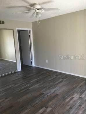 empty room featuring ceiling fan and dark wood-type flooring