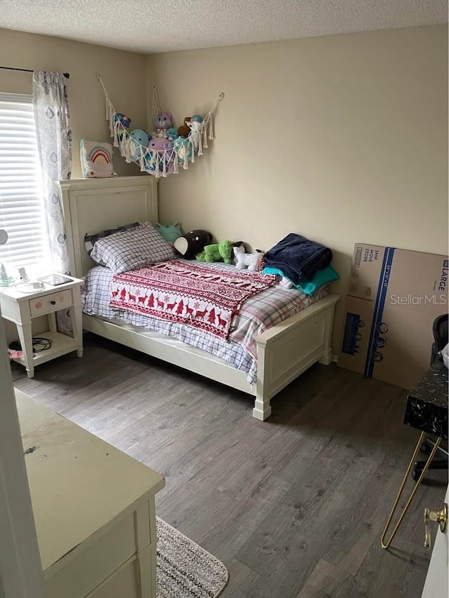 bedroom featuring wood-type flooring and a textured ceiling