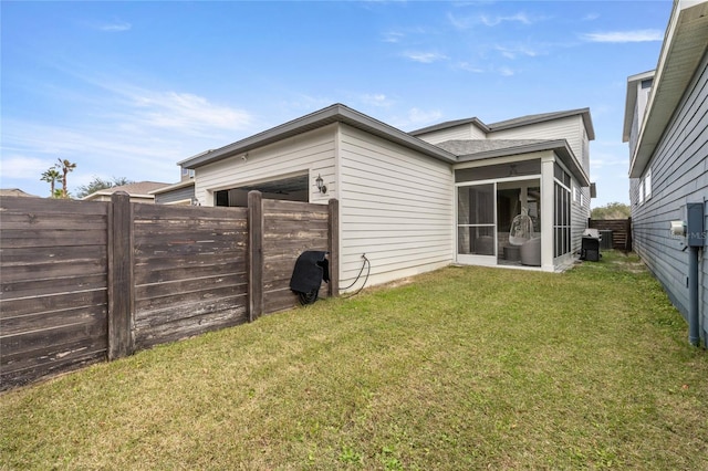 rear view of property with a sunroom and a lawn