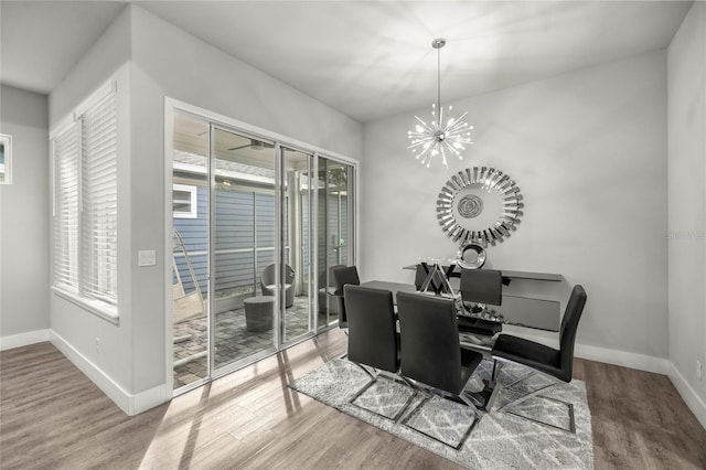 dining space with a wealth of natural light, hardwood / wood-style flooring, and a notable chandelier