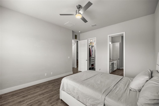 bedroom with ceiling fan, dark hardwood / wood-style floors, connected bathroom, a walk in closet, and a closet