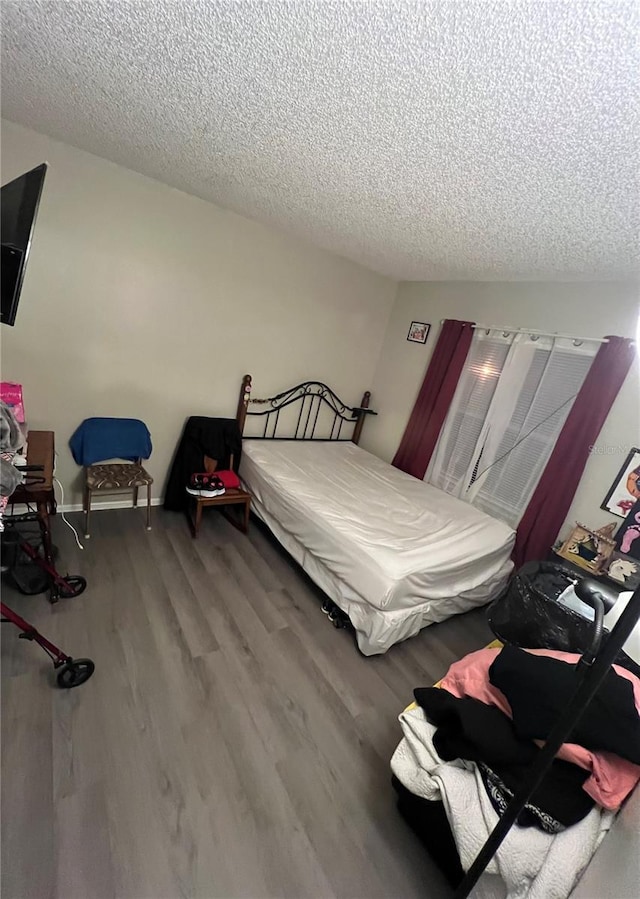 bedroom with hardwood / wood-style flooring and a textured ceiling