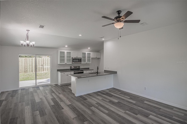 kitchen with kitchen peninsula, appliances with stainless steel finishes, decorative light fixtures, white cabinets, and sink