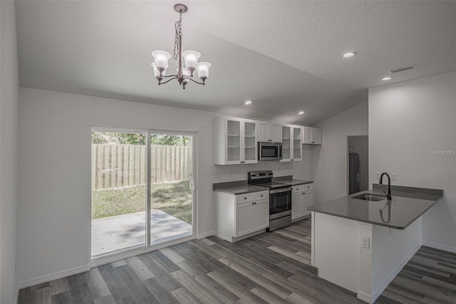 kitchen featuring white cabinets, appliances with stainless steel finishes, decorative light fixtures, sink, and kitchen peninsula