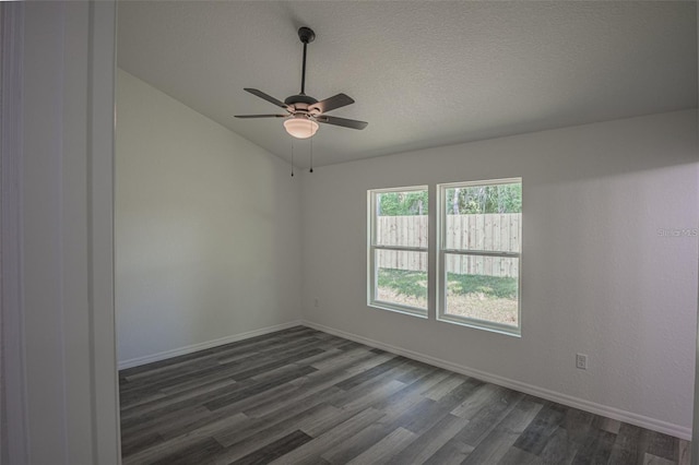 spare room with vaulted ceiling, ceiling fan, dark hardwood / wood-style flooring, and a textured ceiling