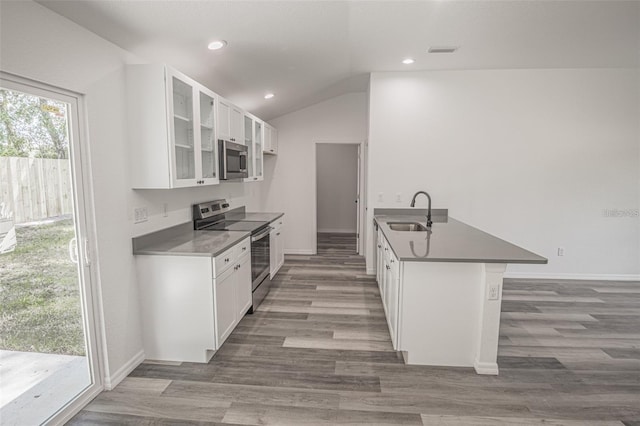 kitchen with kitchen peninsula, a kitchen bar, sink, white cabinetry, and stainless steel appliances