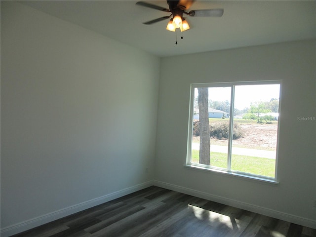 spare room featuring dark wood-style floors, baseboards, and a ceiling fan