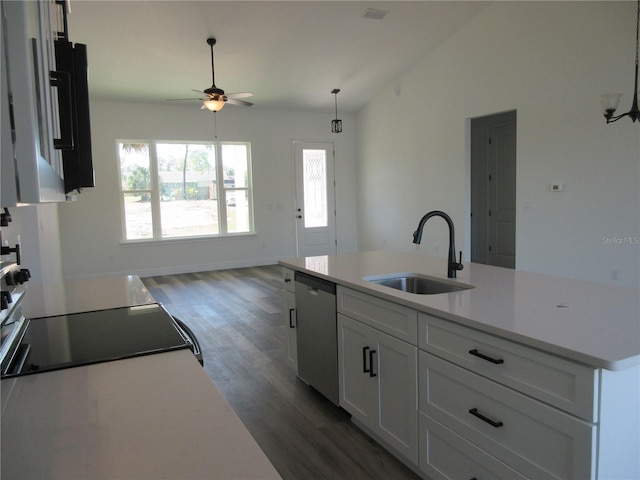 kitchen featuring white cabinets, an island with sink, lofted ceiling, stainless steel dishwasher, and a sink