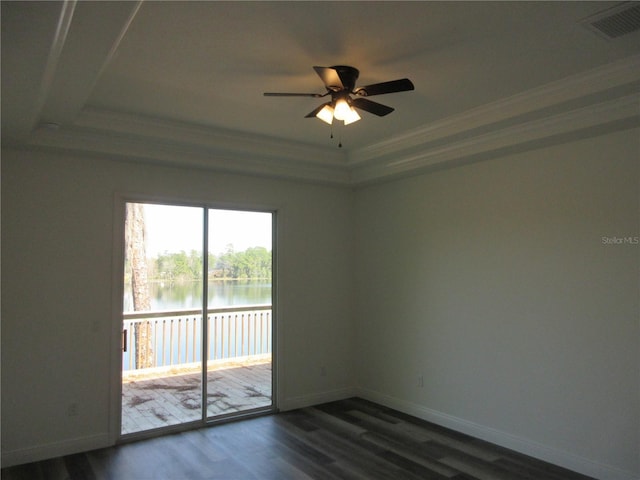 empty room with baseboards, dark wood-type flooring, a water view, and crown molding