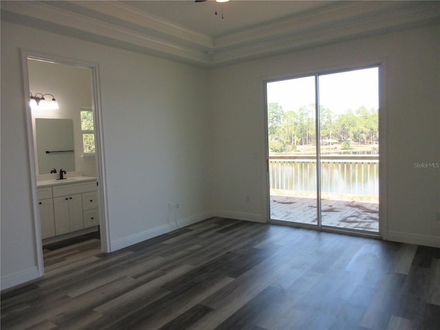 unfurnished bedroom featuring access to exterior, a water view, ornamental molding, and multiple windows