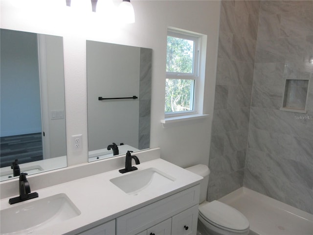 bathroom featuring double vanity, a sink, and toilet