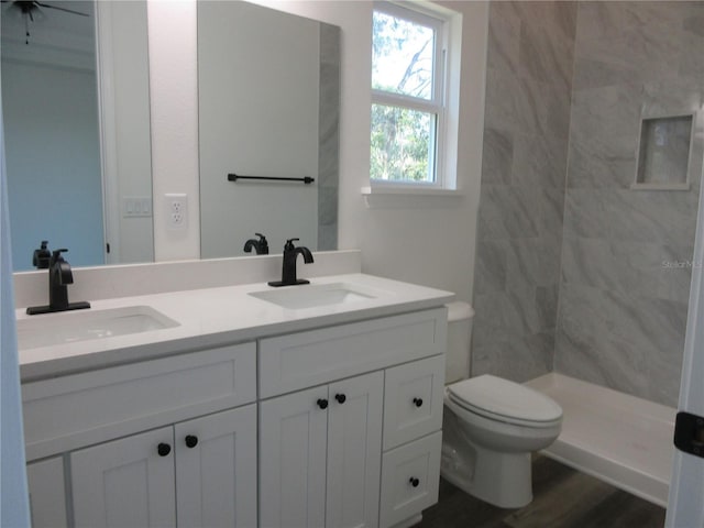 full bath featuring double vanity, a sink, and toilet