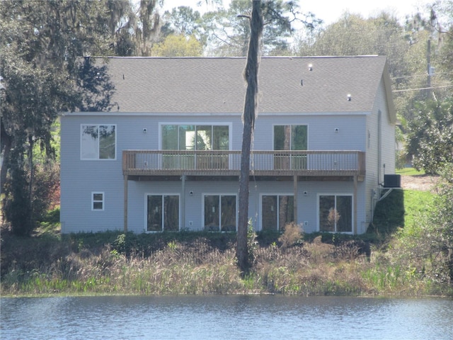 rear view of property with central AC, a water view, and a balcony