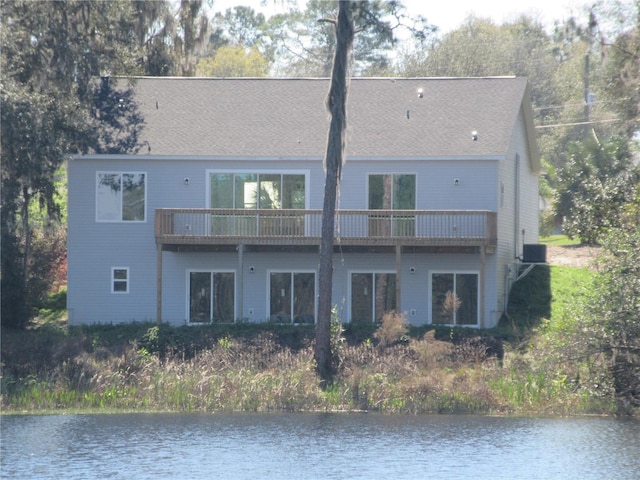 rear view of property with a water view, a balcony, and central AC