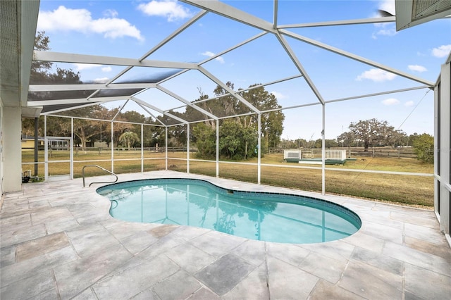 view of swimming pool with a yard, a patio area, and glass enclosure