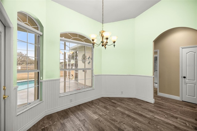 unfurnished dining area with dark hardwood / wood-style floors and a notable chandelier