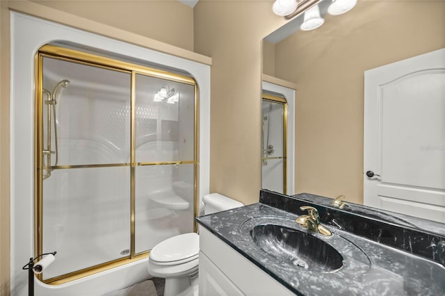 bathroom with toilet, a shower with door, and vanity