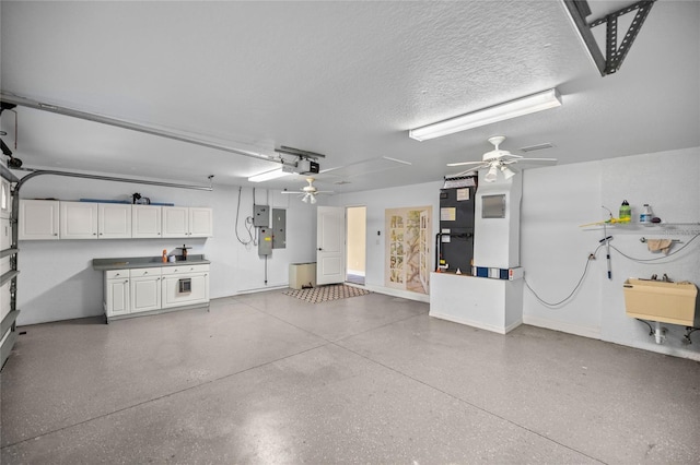 garage with ceiling fan, electric panel, sink, heating unit, and a garage door opener