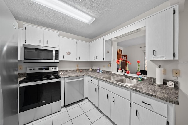 kitchen with white cabinetry, stainless steel appliances, sink, and a textured ceiling