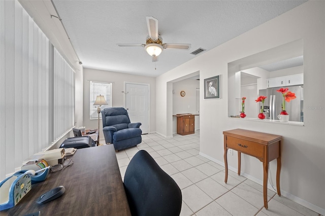 tiled home office with a textured ceiling and ceiling fan